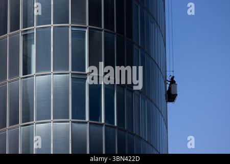 Duesseldorf, Allemagne. 30 juin 2025. Un endroit ombragé à une hauteur élevée : un nettoyeur de façade nettoie les fenêtres du côté ombragé d’un immeuble de bureaux de grande hauteur. Dans les prochains jours, il fera très chaud en Allemagne avec des températures de plus de 30 degrés Celsius. Crédit : Rolf Vennenbernd/dpa/Alamy Live News Banque D'Images