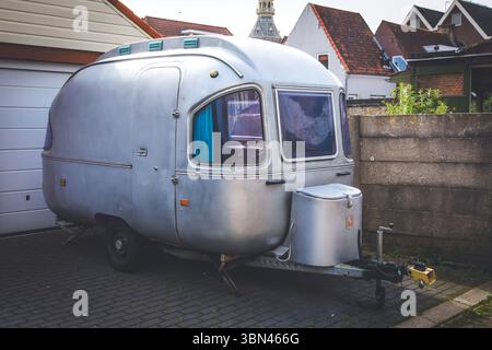 Petite caravane en métal garée devant une maison Banque D'Images
