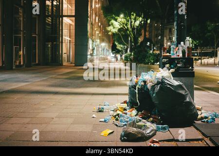 Belgrade, Serbie - 28 juin 2025 : trop de déchets dans une poubelle dans le centre-ville, scène nocturne. Banque D'Images