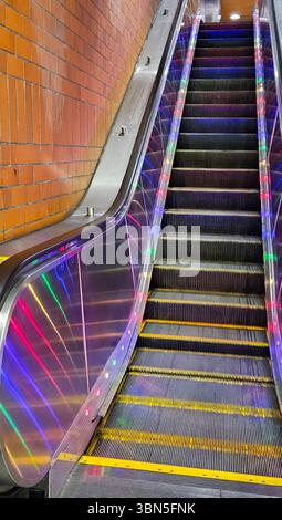 Escalator coloré éclairé par LED dans une station de métro de San Francisco, alliant design moderne et fonctionnalité urbaine dans un cadre souterrain dynamique. Banque D'Images
