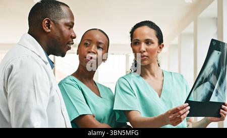 L'équipe médicale discute du diagnostic du patient par radiographie Banque D'Images