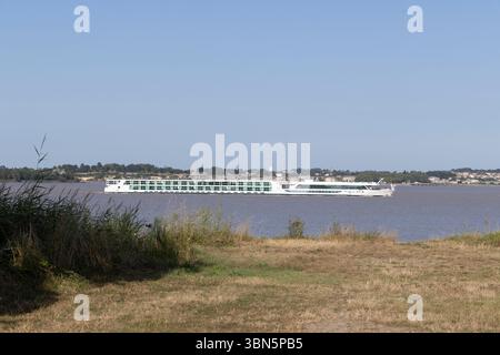 Bateau de croisière blanc naviguant sur l'estuaire de la Gironde près de Cussac Fort Médoc en Nouvelle Aquitaine, France Banque D'Images
