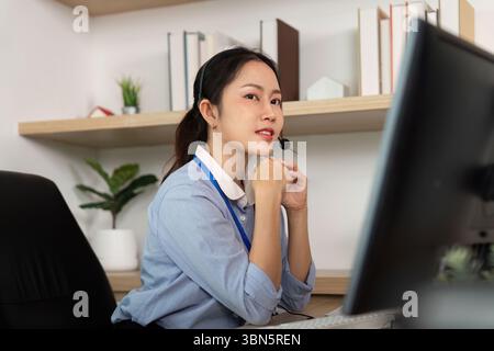Représentant du service clientèle ciblé. Agent féminin envisageant tout en aidant les clients sur un appel. Banque D'Images