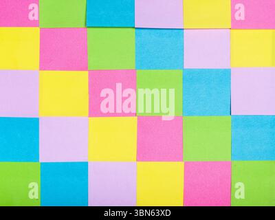Une grille de notes adhésives carrées colorées dans différentes nuances pastel, créant un motif visuellement attrayant et organisé. Banque D'Images