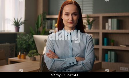 Femme d'affaires dans le bureau fille caucasienne posant les mains croisées confiantes femme d'affaires réussie entrepreneur chef d'investisseur gestionnaire d'employeur plié Banque D'Images