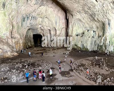 Visiteurs à l'intérieur du vaste dôme de cathédrale de la grotte Devetashka en Bulgarie, une merveille naturelle à couper le souffle de la péninsule balkanique, en Europe de l'est Banque D'Images