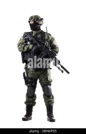 Soldat armé portant un équipement tactique et équipé d'armes à feu, de coussinets de protection et d'équipement de communication, démontrant la disponibilité et le professionnalisme Banque D'Images