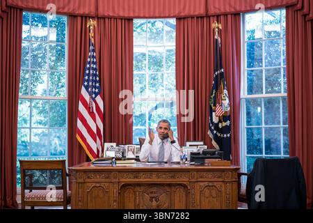 Le président Barack Obama parle au téléphone depuis le Bureau ovale, Washington, DC, le 18 septembre 2015. Image reproduite avec l'aimable autorisation de la Maison Blanche. Banque D'Images