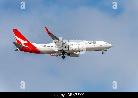 VH-VYJ - Boeing 737-838 - avion Qantas dans le ciel nuageux de l'après-midi atterrissage à Sydney, NSW, Australie. Banque D'Images