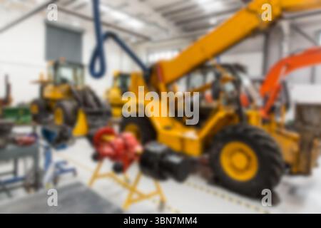 Le télescopique jaune se tient debout dans un atelier de maintenance de conception plate montrant un crochet de levage bleu Banque D'Images