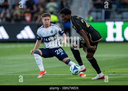 L'attaquant du LAFC Javairô Dilrosun (26) est gardé par la défenseuse des Whitecaps de Vancouver Tate Johnson (28) lors d'un match de la MLS, le dimanche 29 juin 2025, au stade BMO, à Los Angeles, CA. Les Whitecaps ont battu le LAFC 1-0. (Jon Endow/image du sport) Banque D'Images