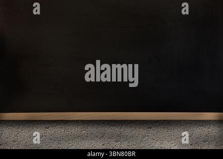 La conception plate montre un tableau vert foncé monté sur le mur avec plateau en bois au-dessus du sol recouvert de moquette Banque D'Images