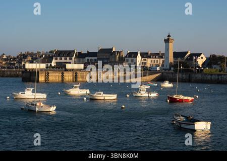 Vue sur le vieux port de Roscoff, Bretagne, avec des bateaux de pêche et de plaisance amarrés à marée haute sous la douce lumière du crépuscule. Banque D'Images