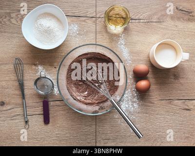 Les ingrédients pour faire des muffins au chocolat sont disposés sur une table en bois. Vue de dessus. Pâtisserie maison. Banque D'Images