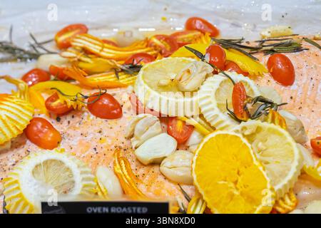 Un gros plan un plat de saumon avec des tranches de citron, tomates cerises, courges jaunes et gousses d'ail.marché gastronomique, Siam Paragon Banque D'Images