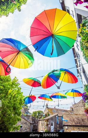 Multicolores, accrocheurs, suspendus, parapluies de couleur arc-en-ciel au Black Horse Hotel à Garrs Lane, Grassington.Yorkshire Dales National Park. Banque D'Images