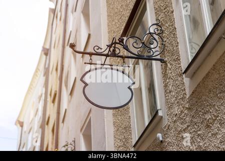 Signalisation vierge vintage unique avec support en fer forgé, parfait pour les boutiques de la vieille ville, les cafés ou les maquettes de logo personnalisées dans des environnements rustiques. Banque D'Images