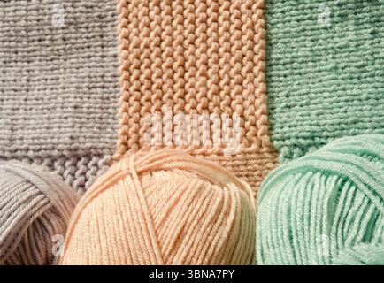 Trois boules douces de fil en pêche, vert menthe et lavande font écho aux couleurs du tricot, mettant en valeur les matériaux et l'artisanat, chacun s. Banque D'Images