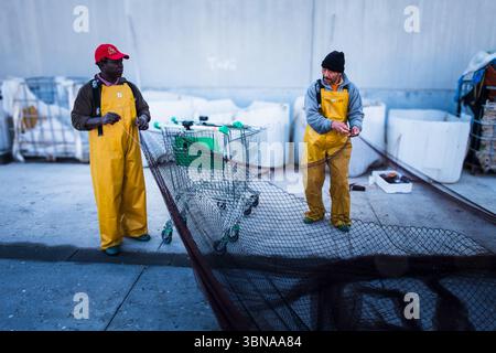 Pêcheurs réparant leurs filets à Gandia Port Espagne Banque D'Images
