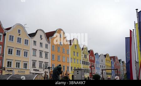 Schärding, le charmant joyau baroque près de la rivière Inn en haute-Autriche. Connu pour la rangée colorée baroque “Silberzeile” de maisons de guilde pastel et des murs médiévaux et portes bien conservés., Une rangée de bâtiments colorés avec des toits à pignons. Les bâtiments sont peints dans une variété de couleurs vibrantes, y compris jaune, orange, rouge, bleu, et blanc, et sont disposés de façon linéaire. La perspective est d'un angle bas, regardant les bâtiments, ce qui crée un sentiment de grandeur et d'échelle. Au premier plan, une statue d'une personne est visible, et une petite structure, peut-être extérieure, est située à proximité Banque D'Images