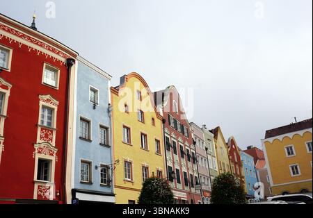 Schärding, le charmant joyau baroque près de la rivière Inn en haute-Autriche. Connu pour la rangée colorée baroque “Silberzeile” de maisons de guilde pastel et des murs médiévaux et portes bien conservés., Une rangée de bâtiments colorés. Les bâtiments sont peints dans une variété de couleurs vibrantes, y compris rouge, bleu, jaune, rose, et orange, et arborent des détails architecturaux ornés. Les bâtiments sont disposés en rangée, avec le plus haut bâtiment à gauche et le plus court à droite. La perspective est d'un angle bas, regardant les bâtiments, ce qui crée un sentiment de grandeur et d'échelle. Le ciel est Banque D'Images