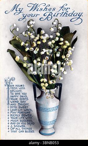 Une carte de voeux d'anniversaire avec un vase bleu et blanc à deux poignées avec un motif de touches grecques, contenant des fleurs blanches de Lily of the Valley et de grandes feuilles vertes, publiée vers 1917. Un verset d'accompagnement commence « vos heures grouillent de plaisir... » Publié par Millar et Lanf Ltd. de Glasgow, Écosse, dans le cadre de leur série nationale. D'une carte postale originale. Banque D'Images
