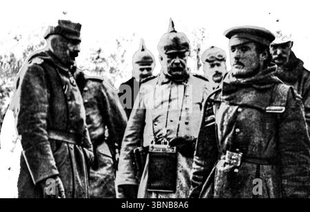 Le Kaiser Guillaume II interroge personnellement un soldat russe capturé au cours de l'hiver 1914-1915. Cette photographie, publiée dans L’illustration, montre l’empereur allemand flanqué d’officiers prussiens en casques de pickelhaube. Un rare aperçu de haut commandement s'engageant directement avec les troupes ennemies au début de la première Guerre mondiale sur le front de l'est. Banque D'Images