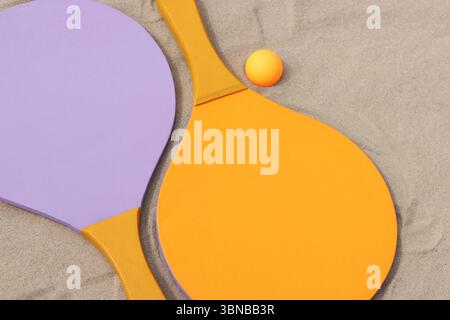 Raquettes en bois vif pour les jeux de plein air. Jeux extérieurs d'été. Sport d'été et concept de jeux. Raquettes de tennis de plage et balle sur sable. Actif Banque D'Images