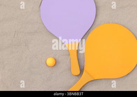 Raquettes en bois vif pour les jeux de plein air. Jeux extérieurs d'été. Sport d'été et concept de jeux. Raquettes de tennis de plage et balle sur sable. Actif Banque D'Images
