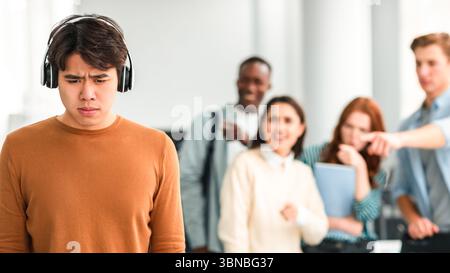 Les gens se moquer et se moquer d'un triste homme asiatique Banque D'Images