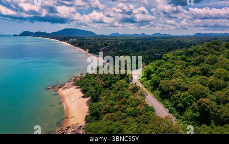 Vue aérienne de la route entre le cocotier et le grand océan en journée à Nakhon si Thammarat, Thaïlande Banque D'Images