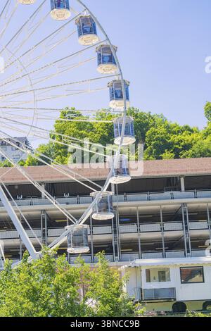 Une grande roue tourne au-dessus d'un bâtiment, entouré d'arbres verts sous un ciel bleu clair, 950 ans Calw, Allemagne, Europe Banque D'Images