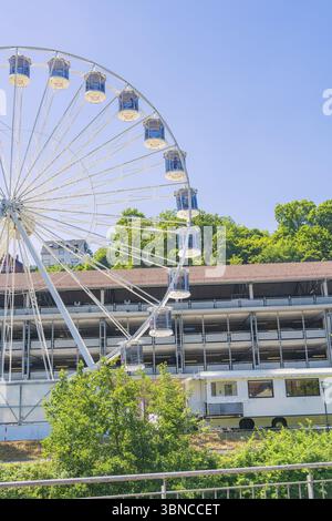 Une grande roue tourne au-dessus d'un bâtiment, entouré d'arbres verts sous un ciel bleu clair, 950 ans Calw, Allemagne, Europe Banque D'Images