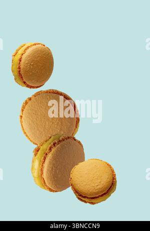 Macarons - dessert français avec garniture orange sur fond bleu, espace de copie Banque D'Images
