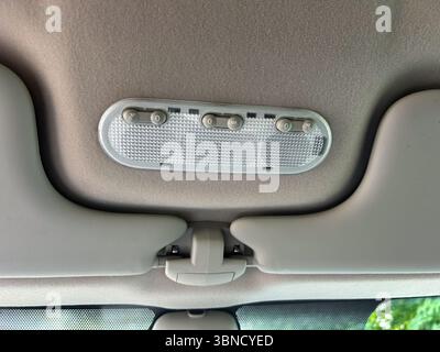 Cette image en gros plan met en évidence un plafonnier au design innovant de voitures, doté de commutateurs conviviaux qui améliorent l'ambiance et la visibilité, assurant la sécurité Banque D'Images
