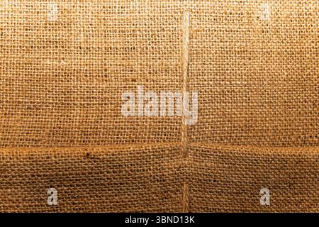 Gros plan de tissu naturel en toile de jute avec couture visible, fond rustique de sac pour l'éco-conception, l'emballage et les projets d'artisanat. Banque D'Images