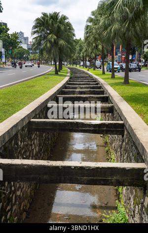 Jakarta, Indonésie - 30 janvier 2025 : long chemin étroit avec une série de petits canaux d'eau qui descendent au milieu. Sektor 7, Bintaro Banque D'Images