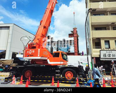 Bâtiment en construction à Tokyo avec grue mobile Tadano orange lumineuse Banque D'Images