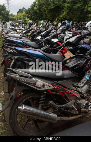 Grand groupe de motos sont garés dans un lot. Les motos sont de différentes tailles et couleurs, et elles sont toutes alignées en rangées. La scène donne de Banque D'Images