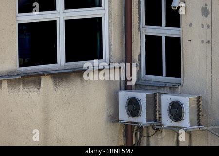 Vieux climatiseurs endommagés nécessitant un entretien et fongicides accrochés au mur extérieur d'un bâtiment d'utilité publique, panne de climatisation, Banque D'Images