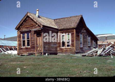 Bodie CA USA 1984. Le département de l'intérieur des États-Unis reconnaît le district historique de Bodie comme un monument historique national. Également enregistrée comme monument historique de Californie, la ville fantôme a été officiellement créée en tant que parc historique d'État de Bodie en 1962. Il reçoit environ 200 000 visiteurs par an. Bodie State Historic Park est en partie soutenu par la Fondation Bodie. En 1876, la Standard Company découvrit un gisement rentable de minerai aurifère, qui transforma Bodie, d'un camp minier isolé comprenant quelques prospecteurs et employés de la compagnie, en une ville-bourgade du Far West. Banque D'Images