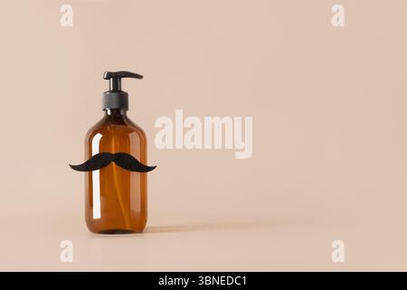 Bouteille cosmétique marron pour savon décoré moustache noire sur fond beige. concept de soins masculins et de bien-être spa. Soin de la barbe. Design créatif pour b Banque D'Images