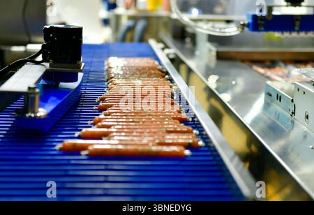 Les machines haute performance emballent des saucisses de produits alimentaires frais transformés. lignes de production alimentaire sur bandes transporteuses, industrie de production alimentaire Banque D'Images
