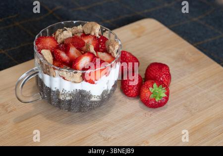Un délicieux et délicieux parfait aux baies composé de graines de chia, de yaourt crémeux et d'une garniture croquante pour le plaisir Banque D'Images