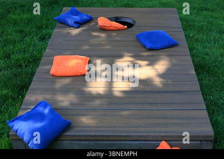 Sacs bleus et orange Cornhole sur une planche lors d'un match dans la cour Banque D'Images