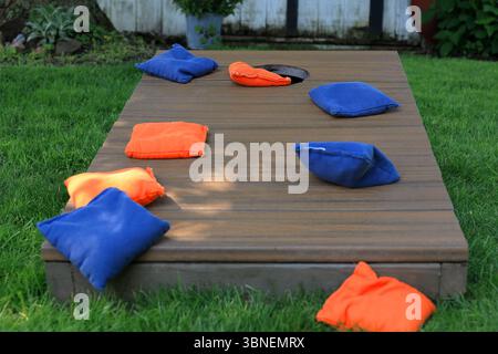 Sacs bleus et orange Cornhole sur une planche lors d'un match dans la cour Banque D'Images