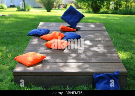 Sac Cornhole bleu en plein air, sur le point de rejoindre des sacs orange sur un panneau Cornhole Banque D'Images