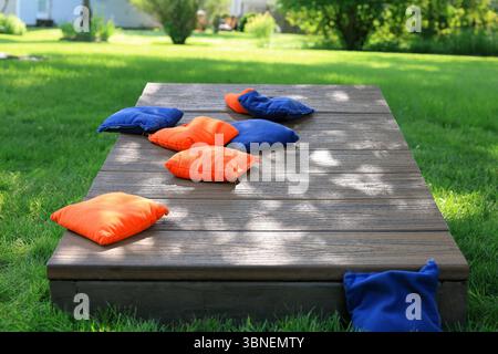 Sacs bleus et orange Cornhole sur une planche lors d'un match dans la cour Banque D'Images