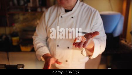 Mains, homme et chef de sushi dans la cuisine, montrant et compétences avec professionnel, cuisine et régime alimentaire. Nigiri, personne et employé avec cuisine asiatique, fruits de mer Banque D'Images