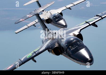 La Saab 105OE de l'armée de l'air autrichienne, immatriculée GD-14 et RE-25, participe à un vol de formation. L'avion, avec une livrée distinctive de l'Association des tigres de l'OTAN, est un jet léger utilisé pour la reconnaissance et l'entraînement. La 105OE de Saab est propulsée par un moteur Rolls-Royce Viper et joue un rôle clé dans les capacités de défense aérienne de l'Autriche. Banque D'Images